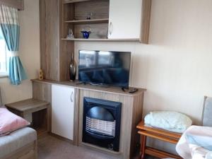 a living room with a tv and a fireplace at Spacious Holiday Home in Exmouth Ocean Views and Pet Friendly in Exmouth