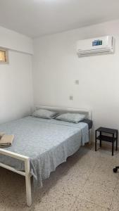 1 dormitorio blanco con 1 cama y aire acondicionado en Larnaca Ancient View Rooms, en Lárnaca