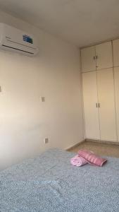Una toalla rosa sobre una cama en una habitación. en Larnaca Ancient View Rooms, en Lárnaca 14 fotos más