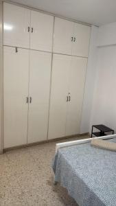 una habitación con armarios blancos y una cama en ella en Larnaca Ancient View Rooms, en Lárnaca