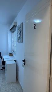 Una puerta blanca en una habitación con luz azul en Larnaca Ancient View Rooms, en Lárnaca