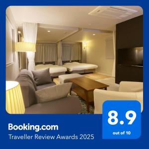 a hotel room with two beds and a living room at precious days inn in Fukuoka