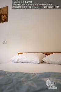 a bed with two white pillows on top of it at 嘉義竹崎白樹腳驛棧萬坪生態包棟烤肉親子民宿 in Fujin