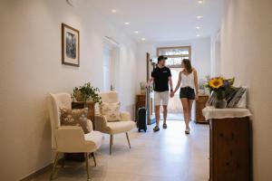 a man and a woman walking down a hallway at Villa Edelweiß in Pertisau