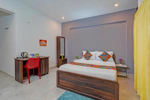 班加罗尔FabHotel Jeevith Garden Residency - Kundalahalli, Brookefield的一间卧室，配有一张床、一张书桌和一张桌子