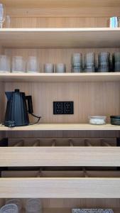 uno scaffale con delle ciotole e un orologio sopra di Hideout Villa Salmi a Säräisniemi Altre 12 foto