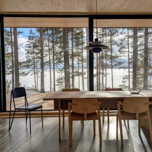 un tavolo da pranzo con sedie e una grande finestra di Hideout Villa Salmi a Säräisniemi