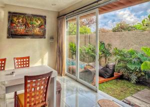 a dining room with a view of a garden at salkhahouse bali cliff one in Ungasan