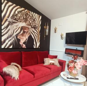 a living room with a red couch and a tv at El Jardín de las Libélulas in Coria