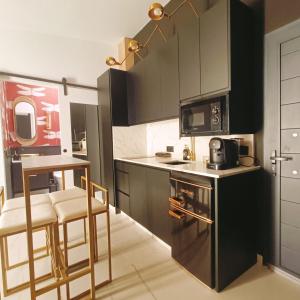 a small kitchen with black cabinets and a microwave at El Jardín de las Libélulas in Coria +52 photos
