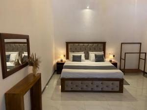 a bedroom with a large bed and a mirror at Mountain Bliss - Ingiriya in Ingiriya