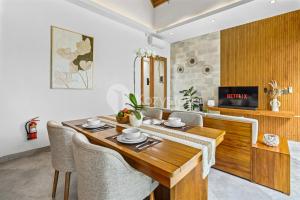 ein Esszimmer mit einem Holztisch und Stühlen in der Unterkunft Oslen Villa by Kozystay - Canggu in Dalung