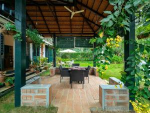 a patio with a table and chairs in a garden at Pine Tree Place By Luxunlock Private Villas in Ammatti