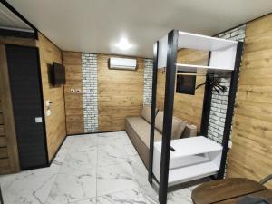 MoiseyevkaGr & Gr的一间镶有木板的房间，楼梯旁有一台电视机。