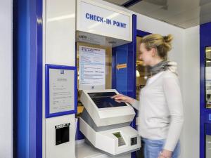 a woman is standing next to an atm machine at Ibis Budget Versailles Coignieres in Coignières +3 photos