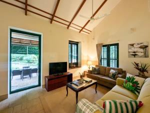 a living room with a couch and a tv at Pine Tree Place By Luxunlock Private Villas in Ammatti