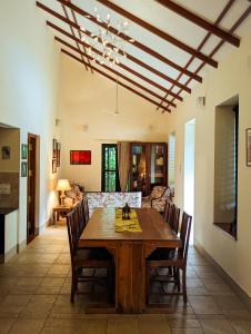a dining room with a wooden table and chairs at Pine Tree Place By Luxunlock Private Villas in Ammatti