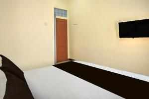 a bedroom with a bed and a flat screen tv at Hotel O Medan near Sun Plaza formerly Medan Baru House in Medan