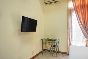 a tv on the wall of a room with a stool at Hotel O Medan near Sun Plaza formerly Medan Baru House in Medan +24 photos