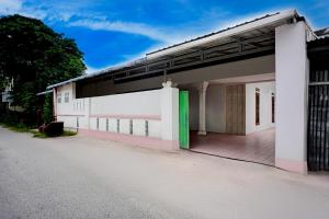 a white building with green doors on the side at Hotel O Medan near Sun Plaza formerly Medan Baru House in Medan