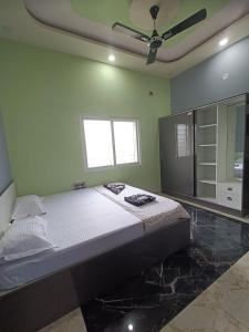 a bedroom with a large bed and a ceiling fan at NANDANAVANA Homestay in New Hampi