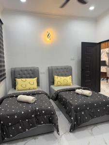 JeliにあるAli Homestay Jeliの寝室に並んで置かれた2つのベッド