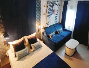 a bedroom with a bed and a blue couch at El Jardín de las Libélulas in Coria