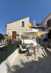 eine Terrasse mit Tisch und Stühlen und einem Sonnenschirm in der Unterkunft Casa Particolari nel Cilento in Giungano + 22 Fotos