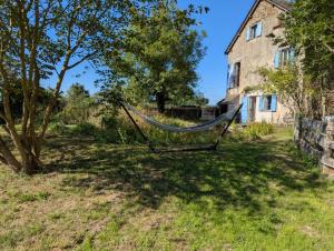 a hammock in a yard next to a house at Saisonnée in Centrès
