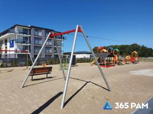 a park with a swing set and a playground at 365PAM - Prywatne apartamenty w hotelu in Sarbinowo