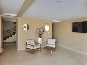 a living room with two chairs and a table at Hotel Rizuna by empire in Paramaribo