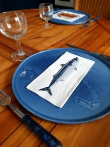 un piatto blu con un pesce sopra su un tavolo di Maison à 300m de la mer Wimereux a Wimereux Altre 5 foto
