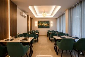 グルガオンにあるHotel Leeef Ninee Hotel in Sector 23, Near Udyog Viharのダイニングルーム(テーブル、緑の椅子付)