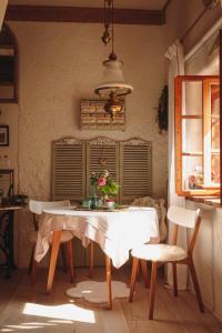 - une table à manger avec une nappe et des chaises blanches dans l'établissement Wohnen & Schlafen im Cottage, à Wundschuh