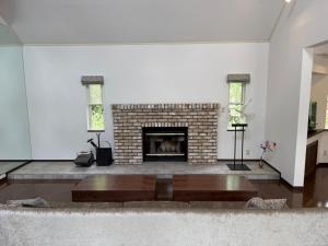 a living room with a brick fireplace and two windows at Private villa in the Shizuoka Highlands in Susono