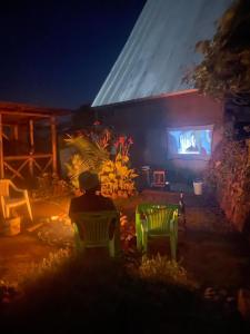 a person sitting in chairs watching a presentation on a stage at Mai Kilimanjaro Home Stay in Marangu