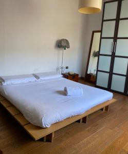 a large bed in a room with white sheets at City House Cagliari in Cagliari