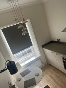 a small kitchen with a white table and a window at The Boyne Arms in Burwarton