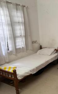 a bed in a room with white curtains at Honza Hostel in Cochin