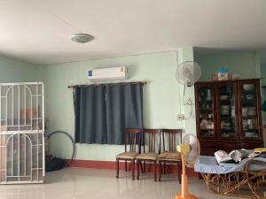 a room with a room with chairs and a crib at Garden house in Ban Krok Khi Nu