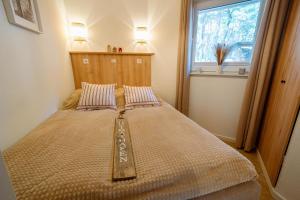 a large bed in a room with a window at Ferienhaus Tipi 365 - strandnahes Ferienhäuschen mit Terrasse und kostenfreier Nutzung des AHOI!-Schwimmbades in Sellin in Göhren +25 photos