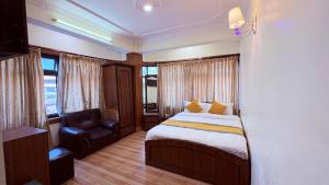 une chambre avec un lit et une chaise dedans dans l'établissement Hotel Divine Inn, à Katmandou