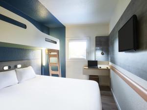 Ένα ή περισσότερα κρεβάτια σε δωμάτιο στο Ibis Budget Marmande