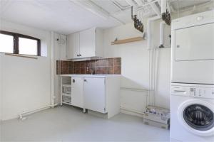 a white kitchen with a washing machine in it at Cozy & light-filled home in Landskrona +2 photos