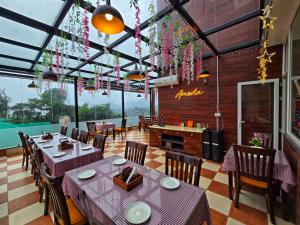 ein Restaurant mit Tischen und Stühlen in einem Raum in der Unterkunft Amoda - Best Hotel in Dharamshala in Dharamshala