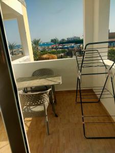 um quarto com uma mesa, uma cadeira e uma varanda em Porto View Touristic Center em Hurghada