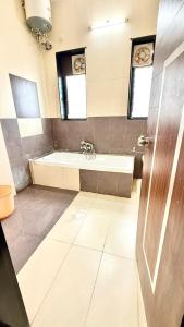 a bathroom with a bath tub and a sink at Hotel Mahendra, Karad in Karad