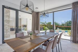 a dining room with a wooden table and chairs at Contemporary Villa Nada with Pool and Sauna in Tinjan
