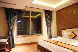a bedroom with a bed and a window and a desk at Thảo Ngân Pleiku Hotel in Plei Khưn +20 photos