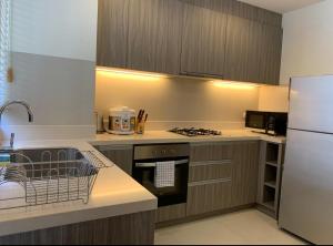 eine Küche mit Herd und Kühlschrank in der Unterkunft Laguna Parkside 5 bedroom villa with pool near the beach in Laguna Phuket